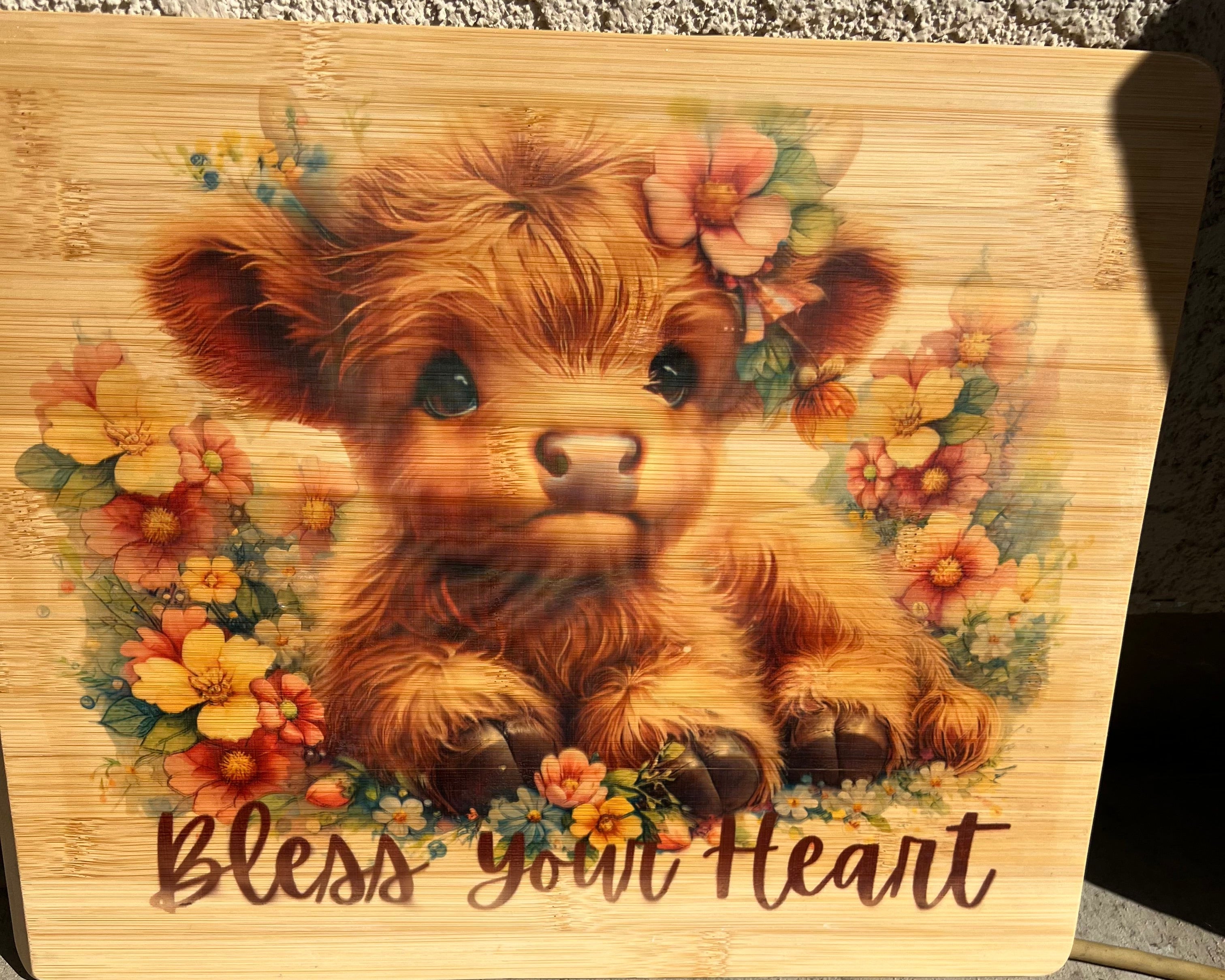 Wooden cutting board with a bear illustration and floral design on a textured surface